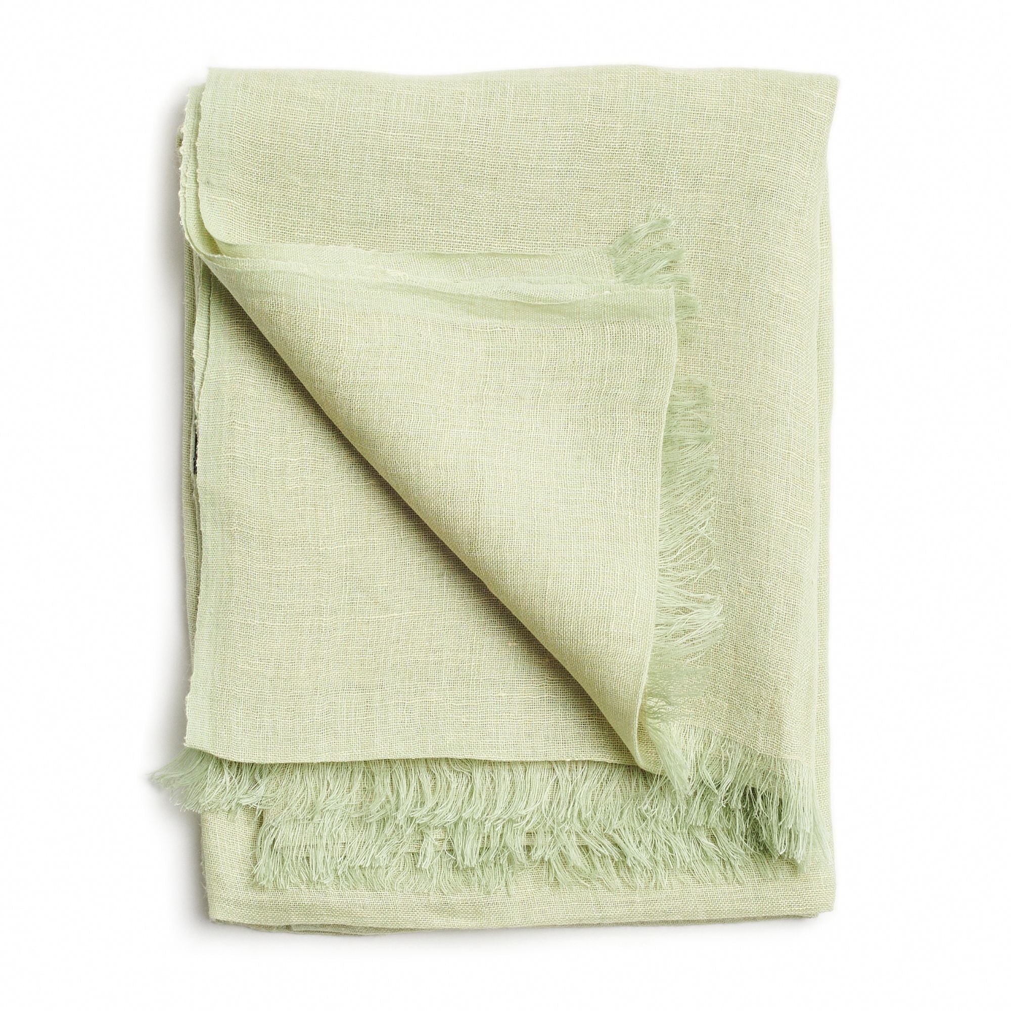 Green handwoven scarf draped on a hanger, showcasing soft texture and natural craftsmanship.