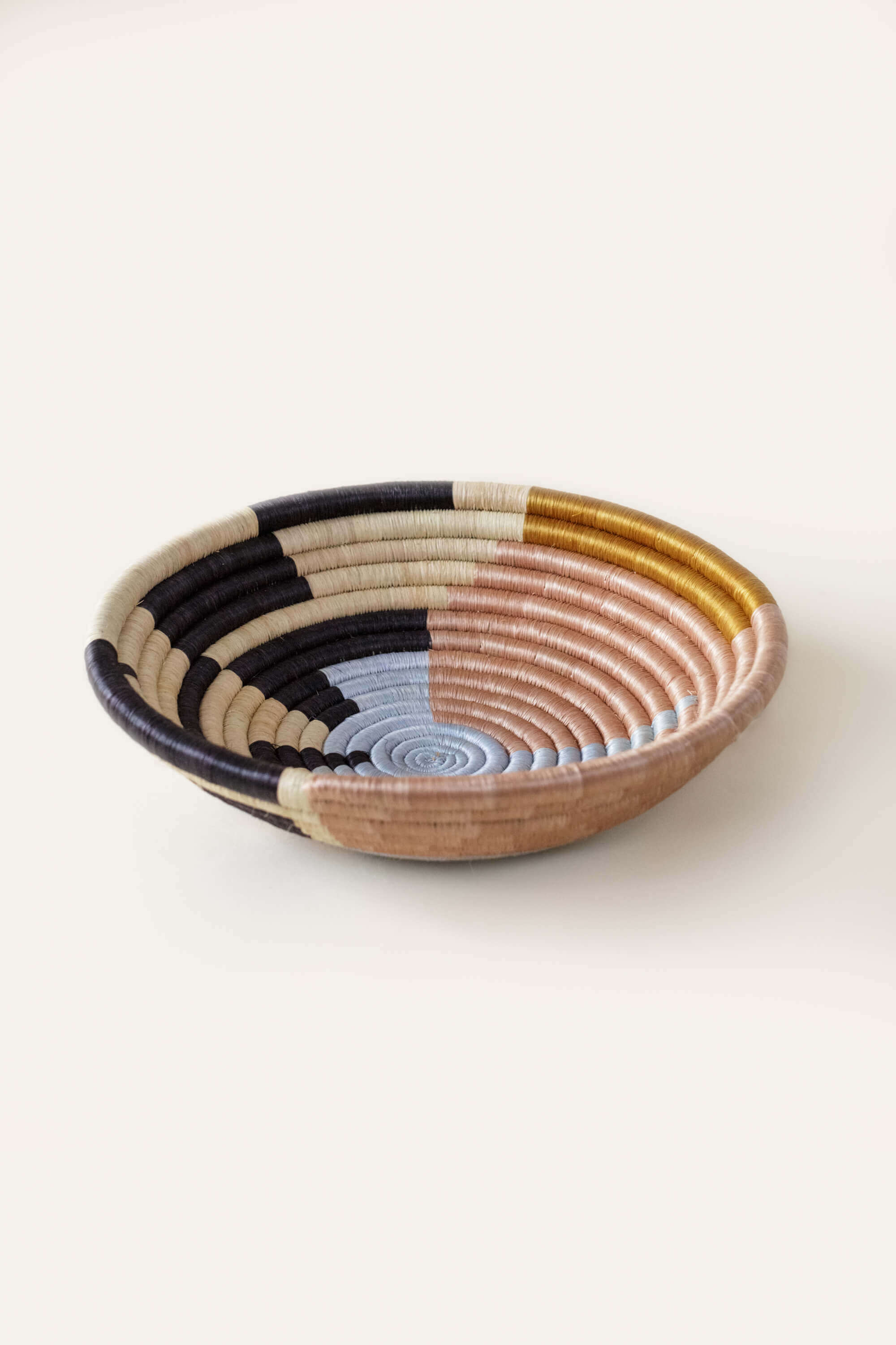 Brown and black raffia basket with a bold woven design, handmade for decorative use on tables, shelves, or walls.