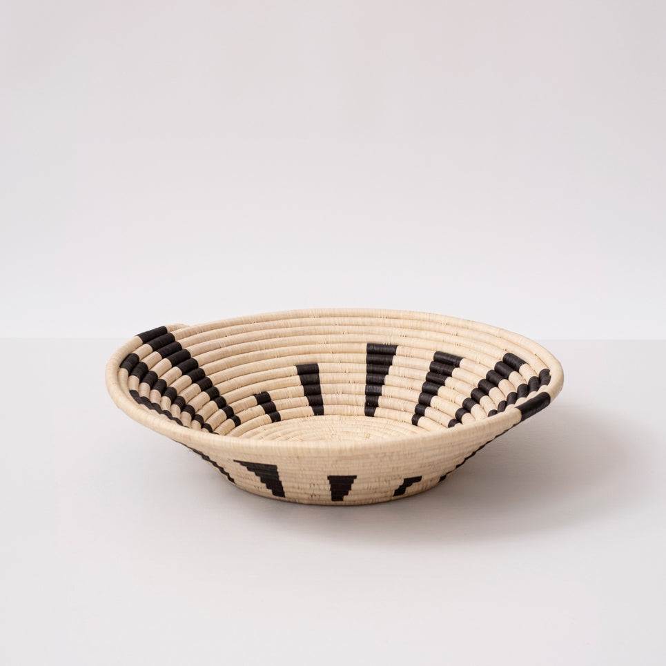 Brown and black raffia basket with a bold woven design, handmade for decorative use on tables, shelves, or walls.