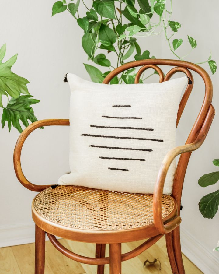 Black and white throw pillow with geometric design, artisan-made for a modern and cozy home accent.