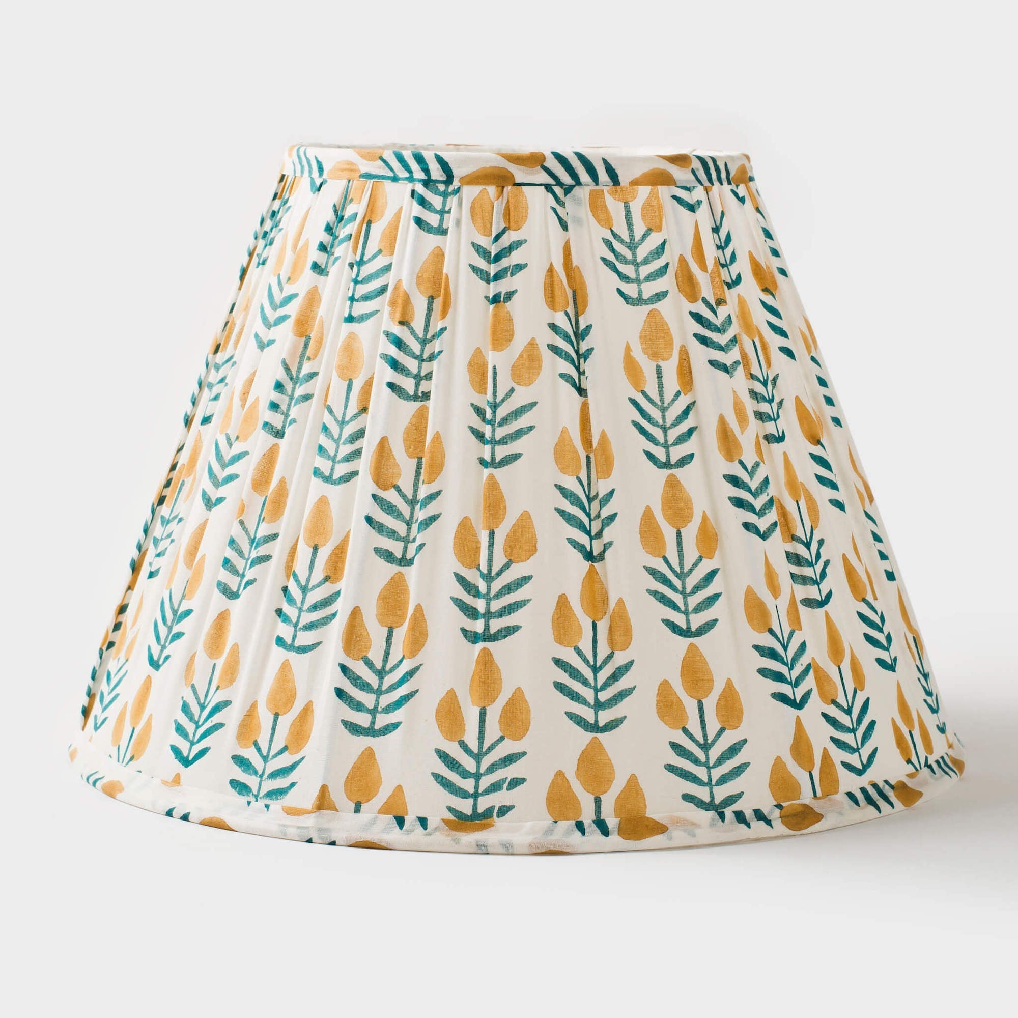 Lamp shade with yellow and green leaf pattern on a white background