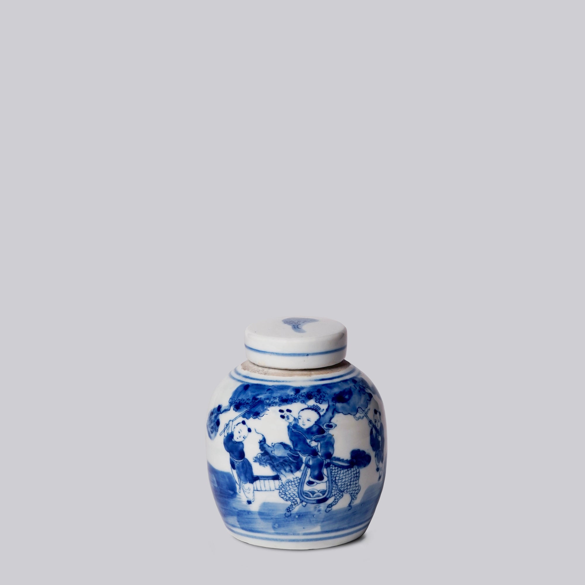 Blue and white ceramic jar with lid on a light gray background