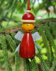 Decorative wooden angel hanging on a green tree branch