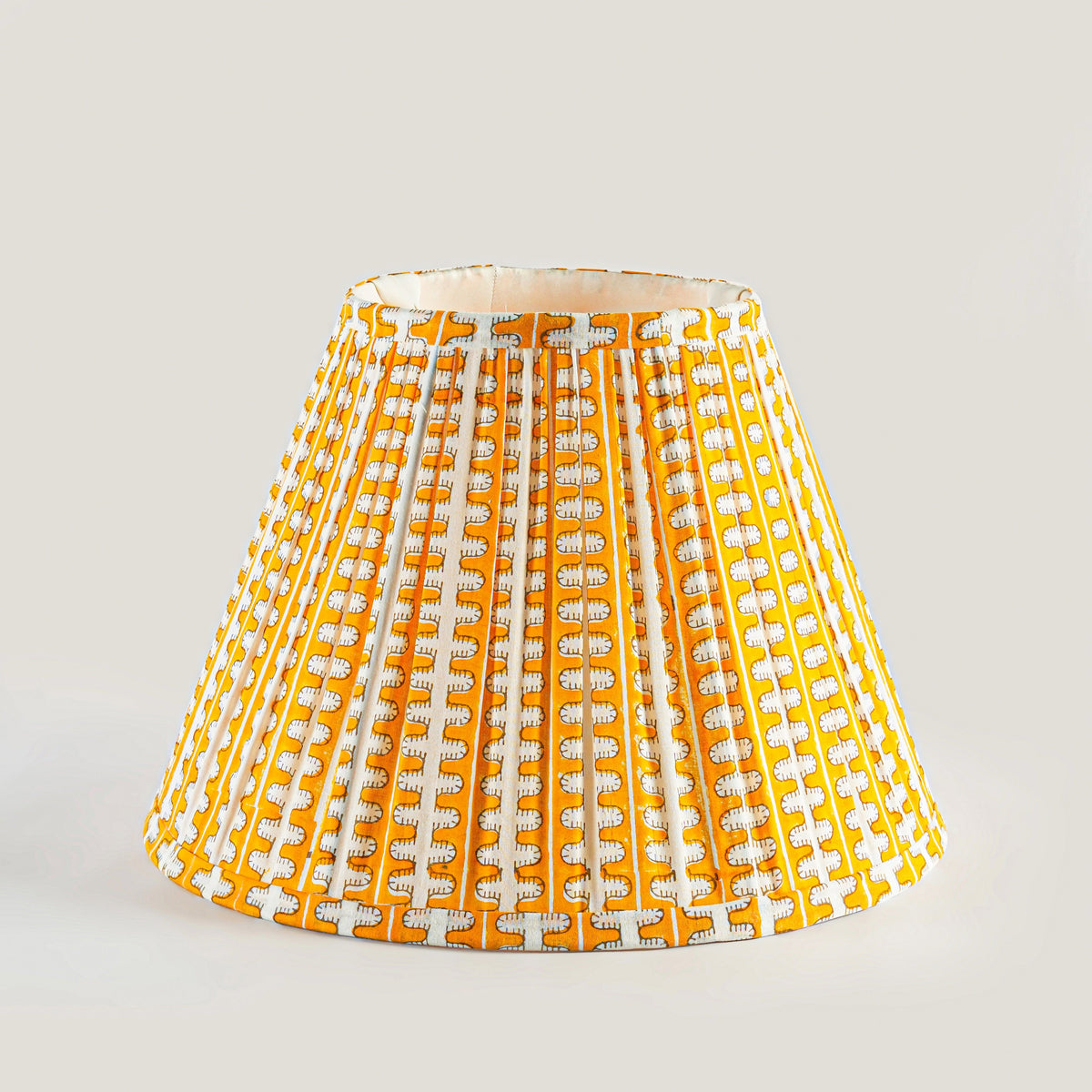 Yellow and white patterned lampshade on a light gray background