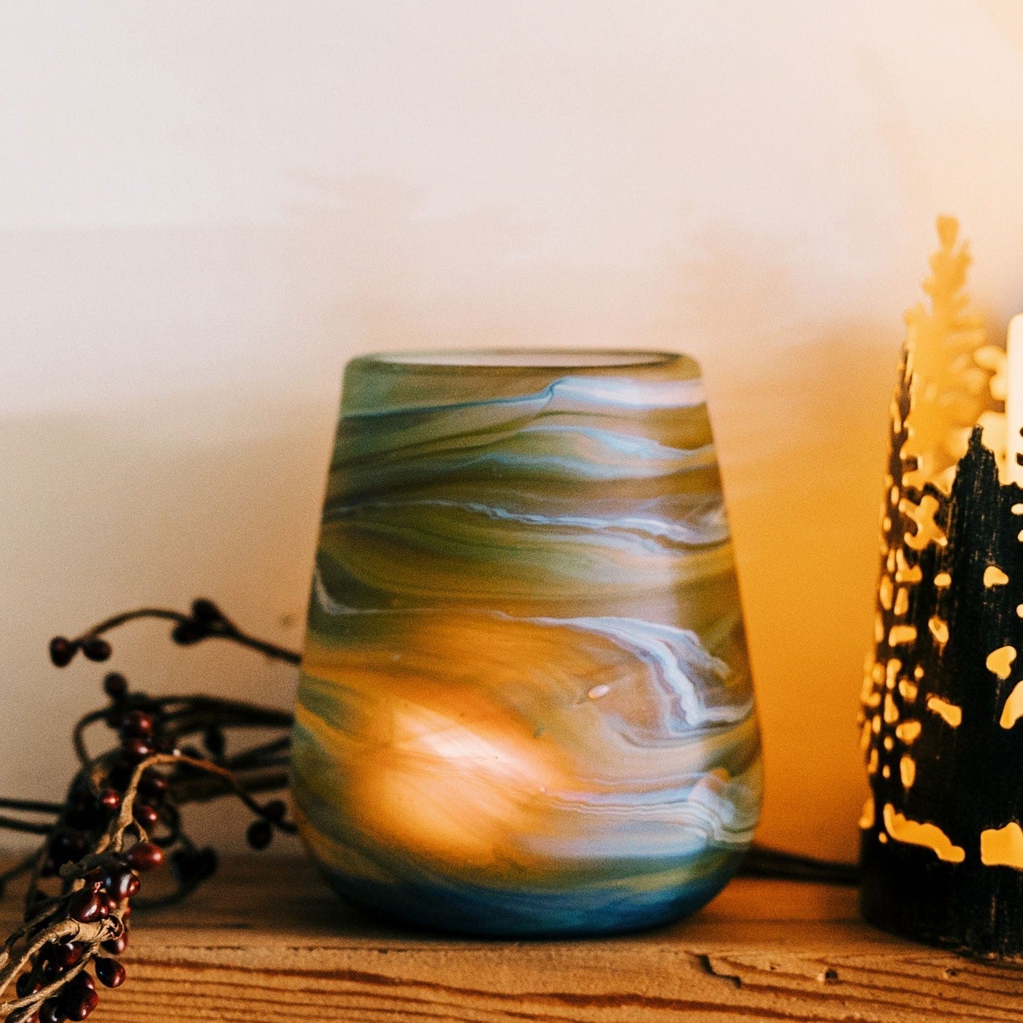 Glass candle holder on a wooden surface with warm lighting