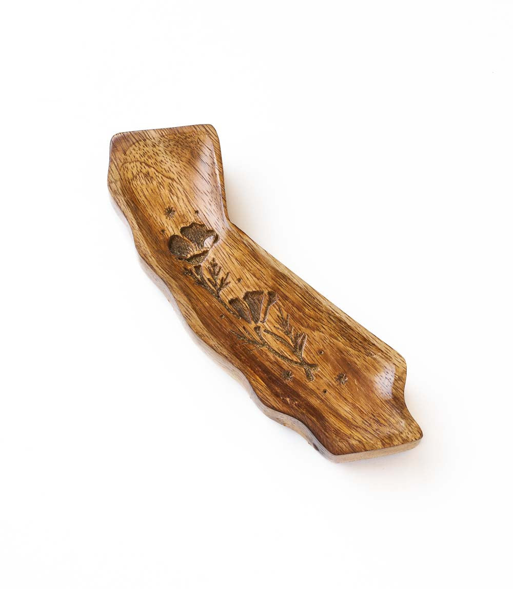 Wooden trinket dish with engraved design on a white background