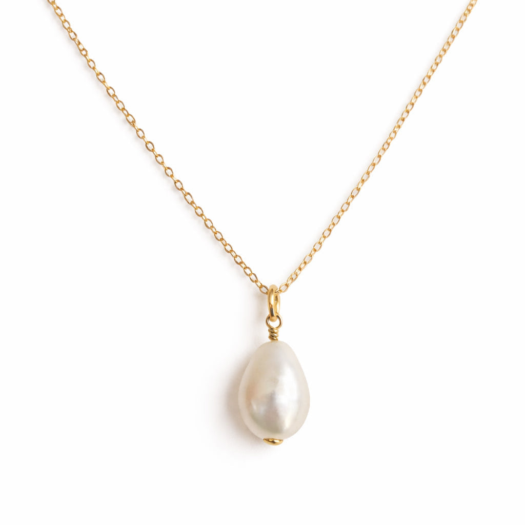 Pearl necklace on a gold chain against a white background