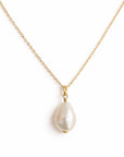 Pearl necklace on a gold chain against a white background