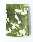 Green linen table runner with white floral pattern on a white background