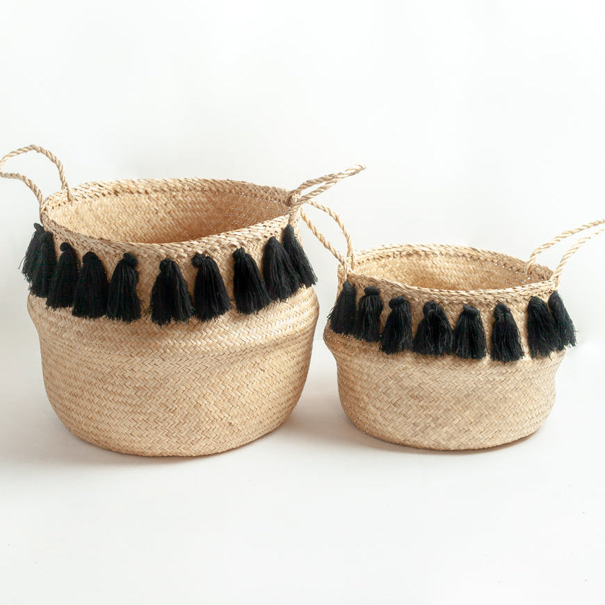 Two woven baskets with black tassels on a white background