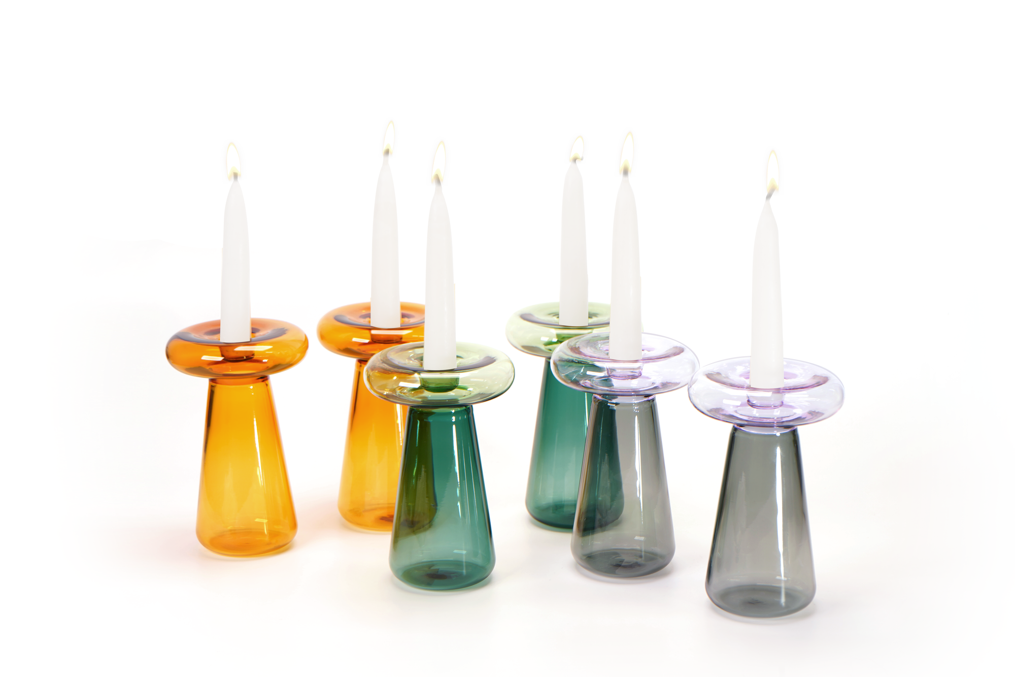 Set of colorful glass candle holders with candles on a white background