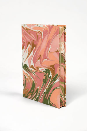 Marbled notebook with pink, green, and white design on a white background