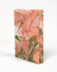 Marbled notebook with pink, green, and white design on a white background