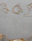 Three Rattan wall art pieces on a gray wall with wicker chairs at the bottom.