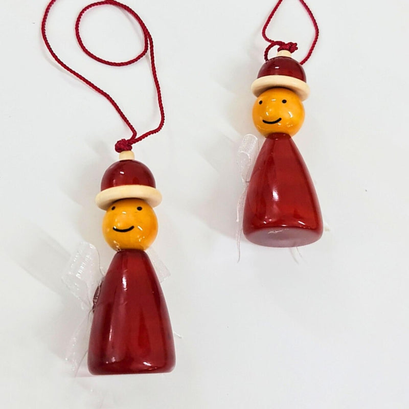 Two wooden Christmas ornaments designed as santa's elves wearing Santa hats on a white background.