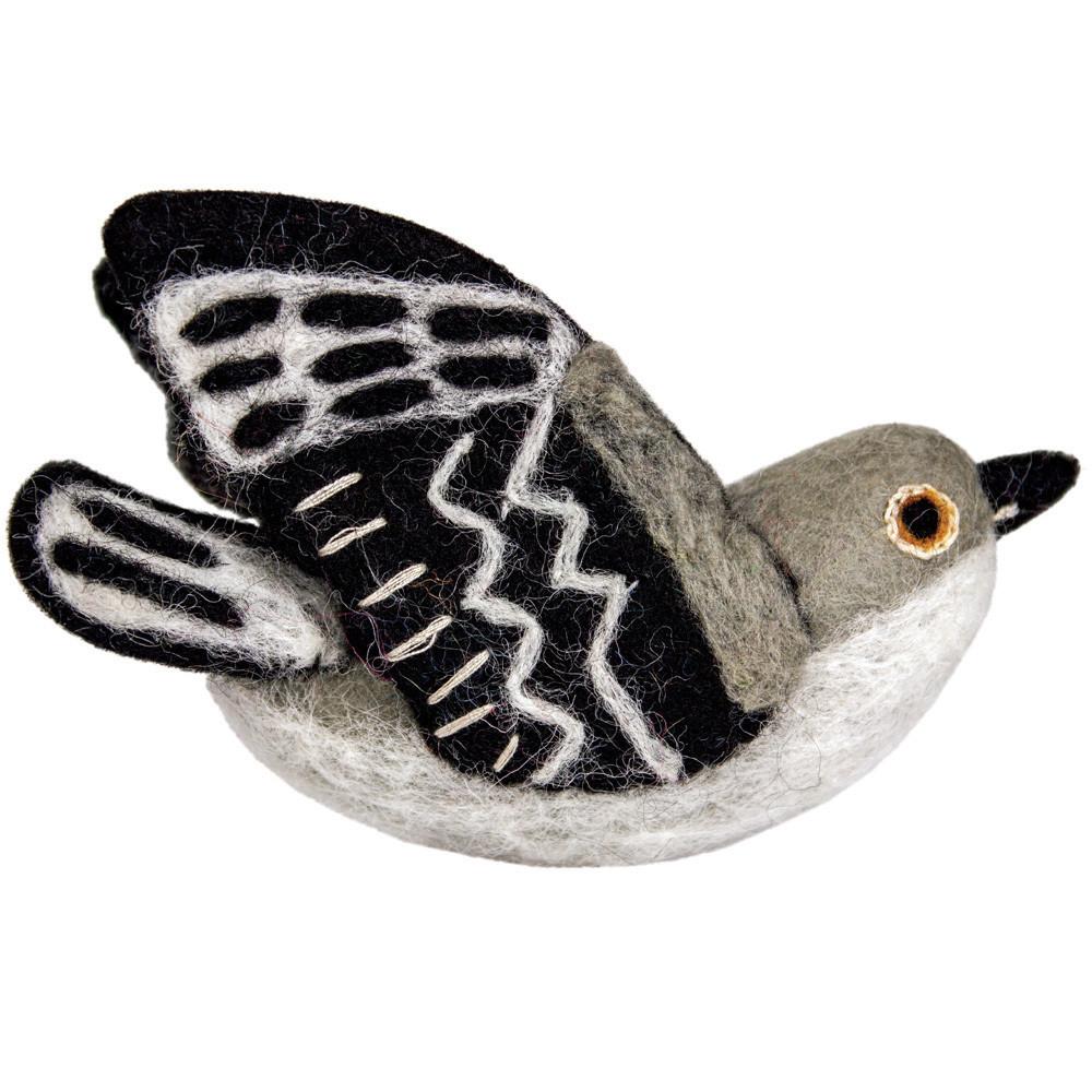 Felted toy mockingbird with black and white wings on a white background