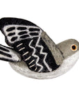 Felted toy mockingbird with black and white wings on a white background
