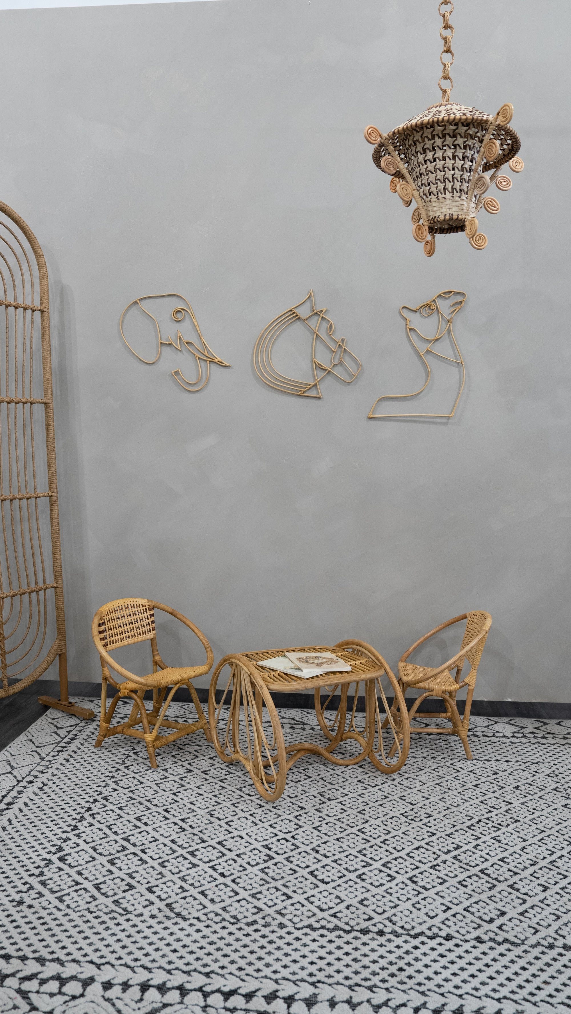 Rattan furniture set with decorative wall art in a room with a patterned rug.