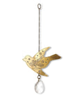 A brass suncatcher in the shape of an engraved bird with a teardrop crystal at the bottom, hanging from a wire.