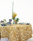 Table setting with a floral tablecloth, plates, and decorative elements on a white background