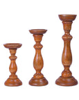A set of three brown wooden pillar candle holders in varying sizes, designed to hold candles