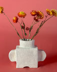 Porcelain vase with dried flowers on a pink background