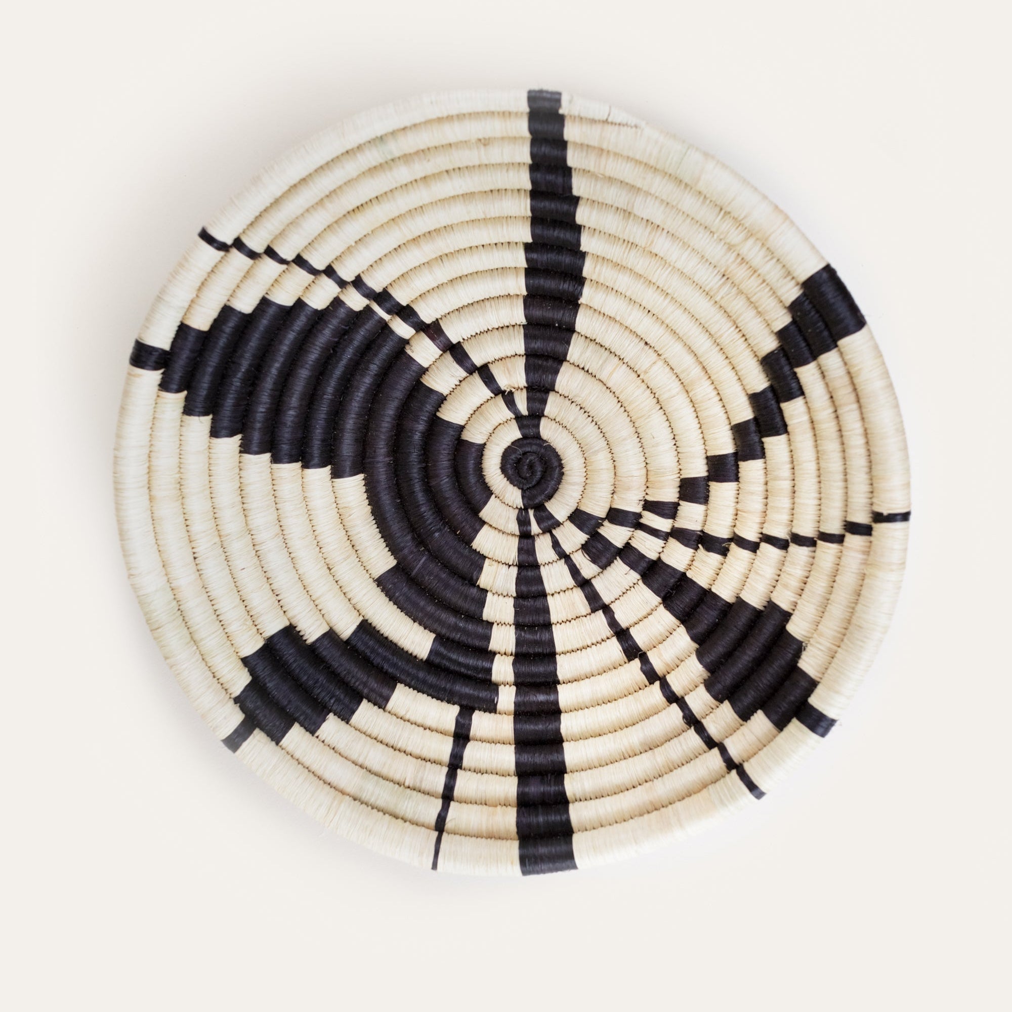 Woven basket with black and white pattern on a light gray background