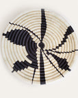 Woven basket with black and white pattern on a light gray background
