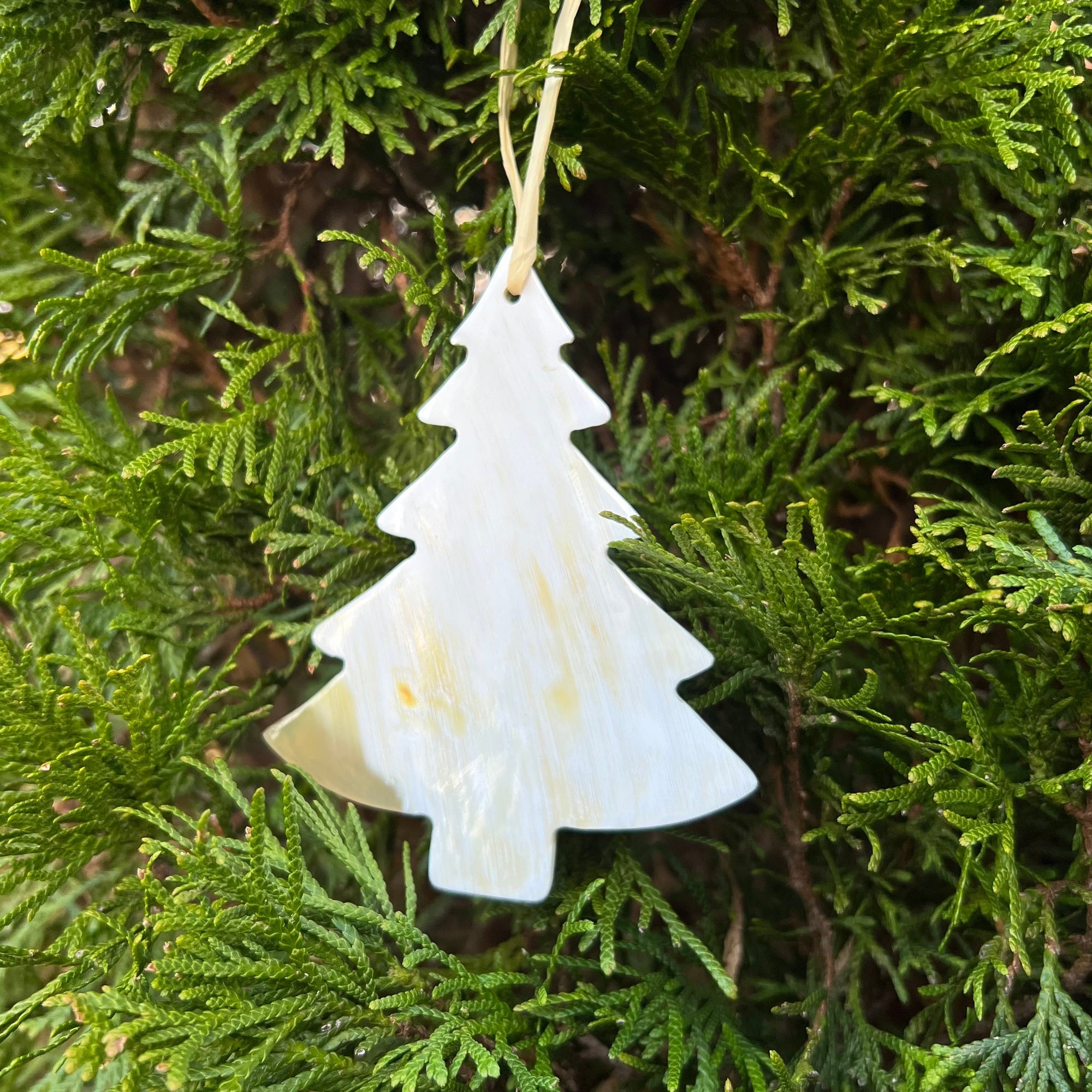 Beige Christmas tree ornament made of horn hanging on a christmas tree
