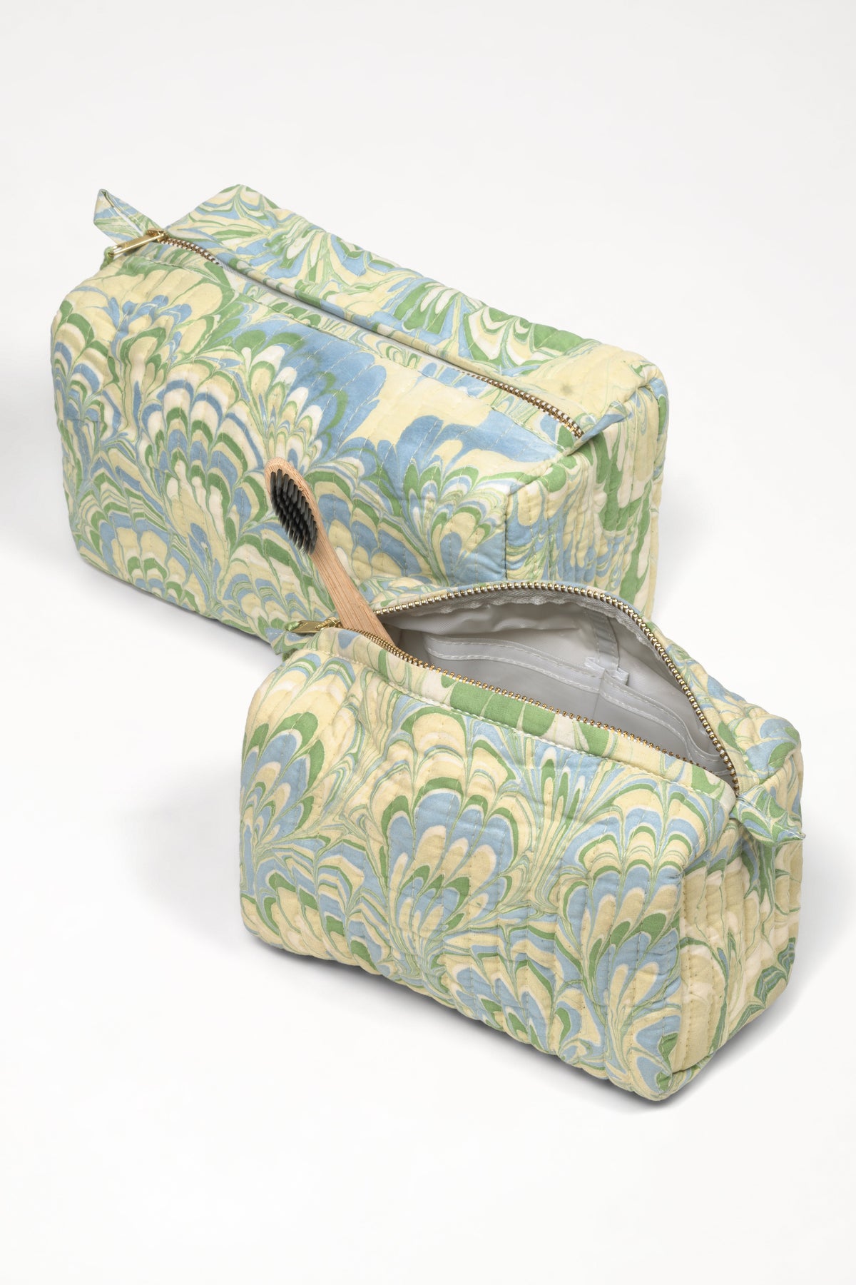 Two patterned toiletry bags on a white background