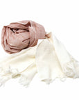 A hand-dyed cotton scarf in rust and cream with fringe, displayed on a white background.