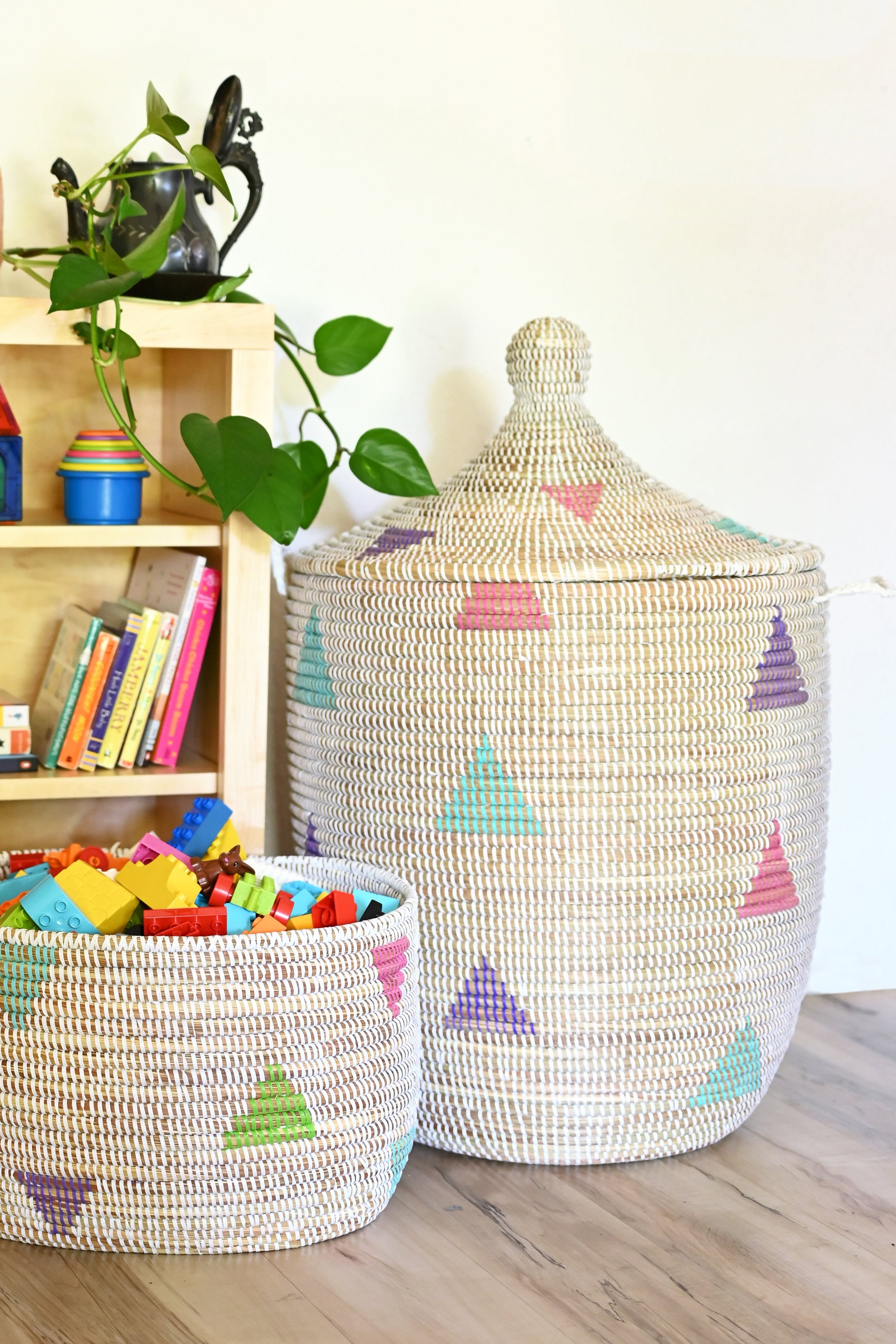 Woven baskets with colorful triangle patterns on a wooden floor.
