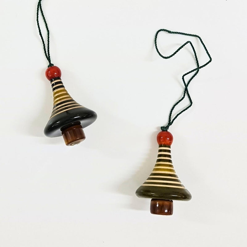 Two striped ceramic bell christmas tree ornaments on strings against a white background