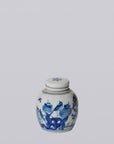 Small ceramic jar with blue floral and bird design on a white background