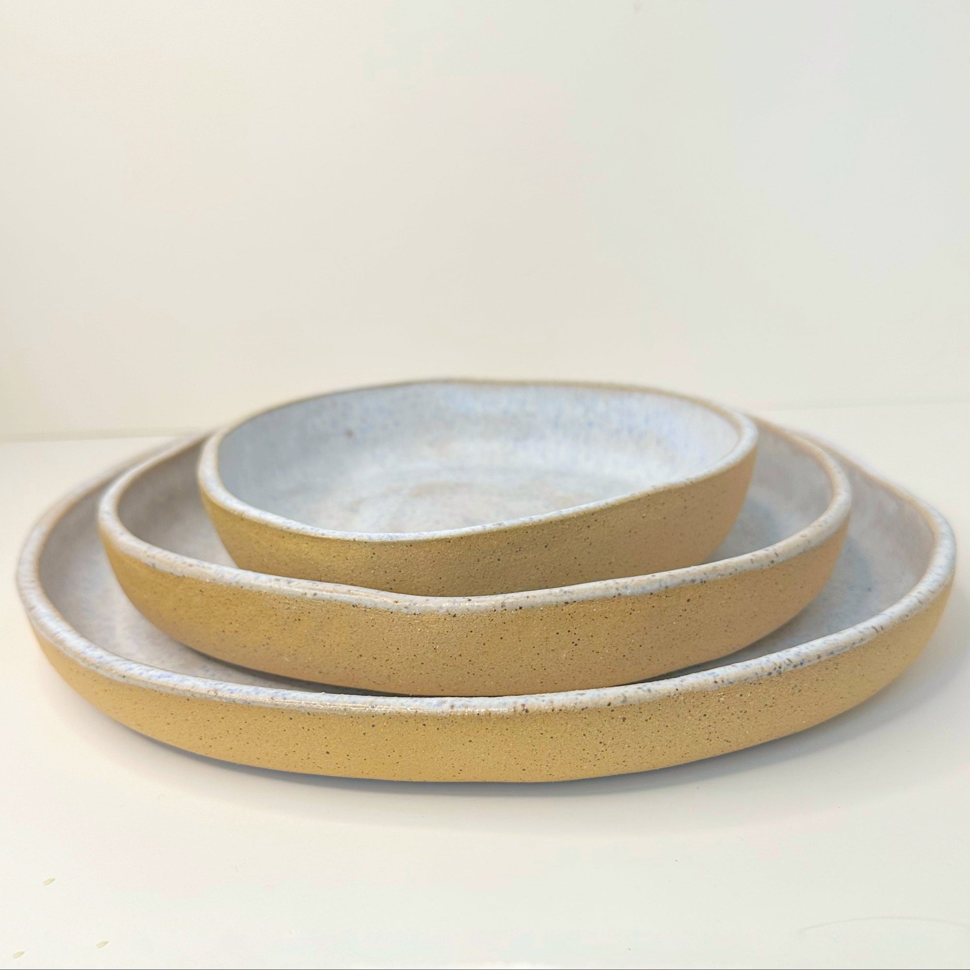 Set of three ceramic bowls with a textured finish on a white background