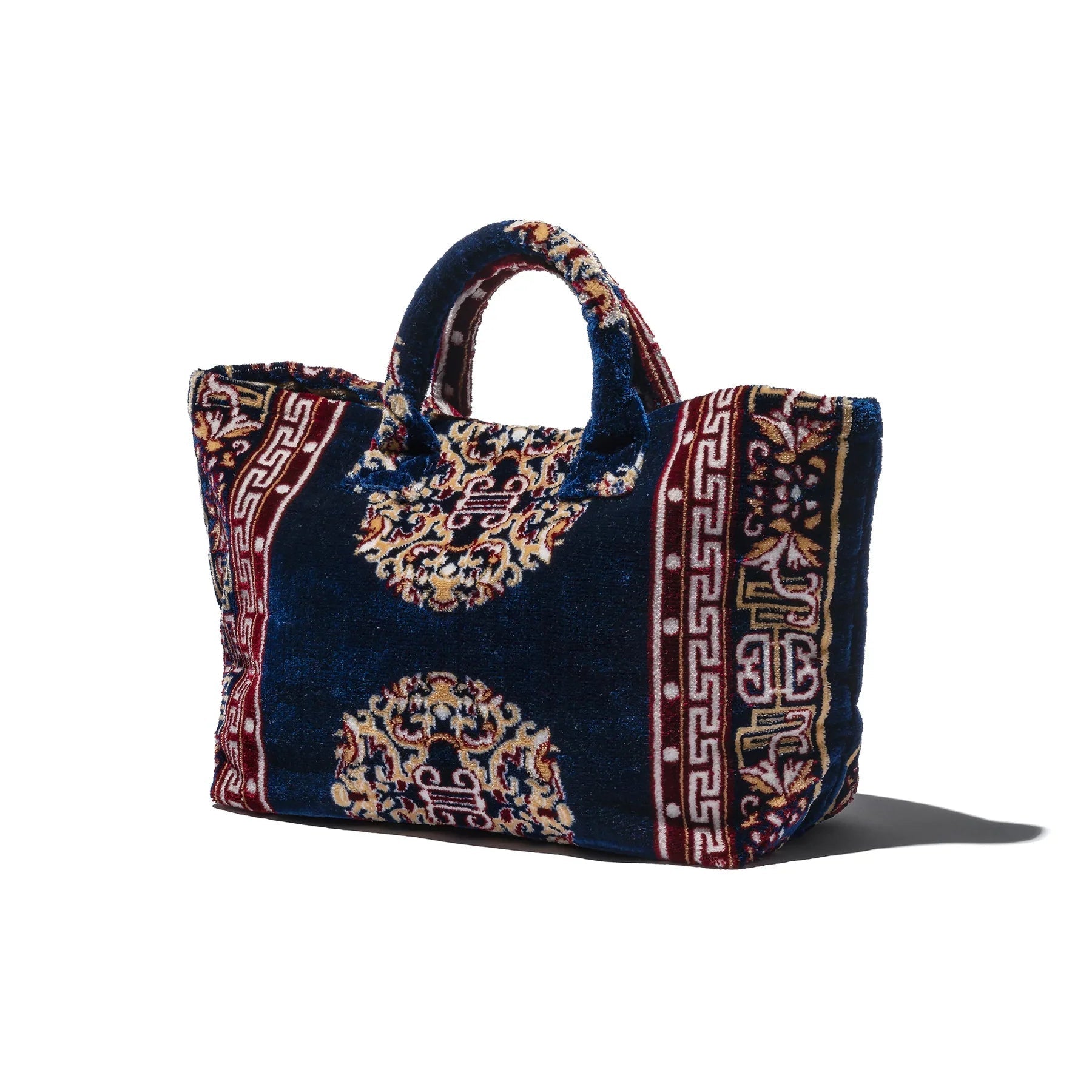 Decorative fabric carpet bag with intricate patterns on a white background