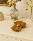 Decorative mushroom design trinket dish on a dresser including a vase, jewelry display, and a framed painting.