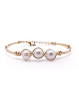 A gold-plated bracelet featuring three fresh water pearls with a gold-plated wire and clasp.