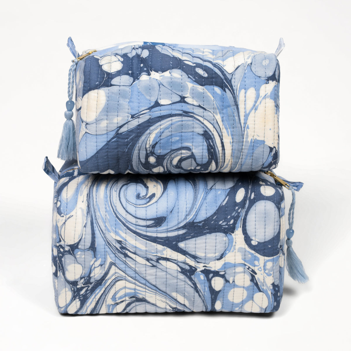Two blue and white patterned bags stacked on a white background