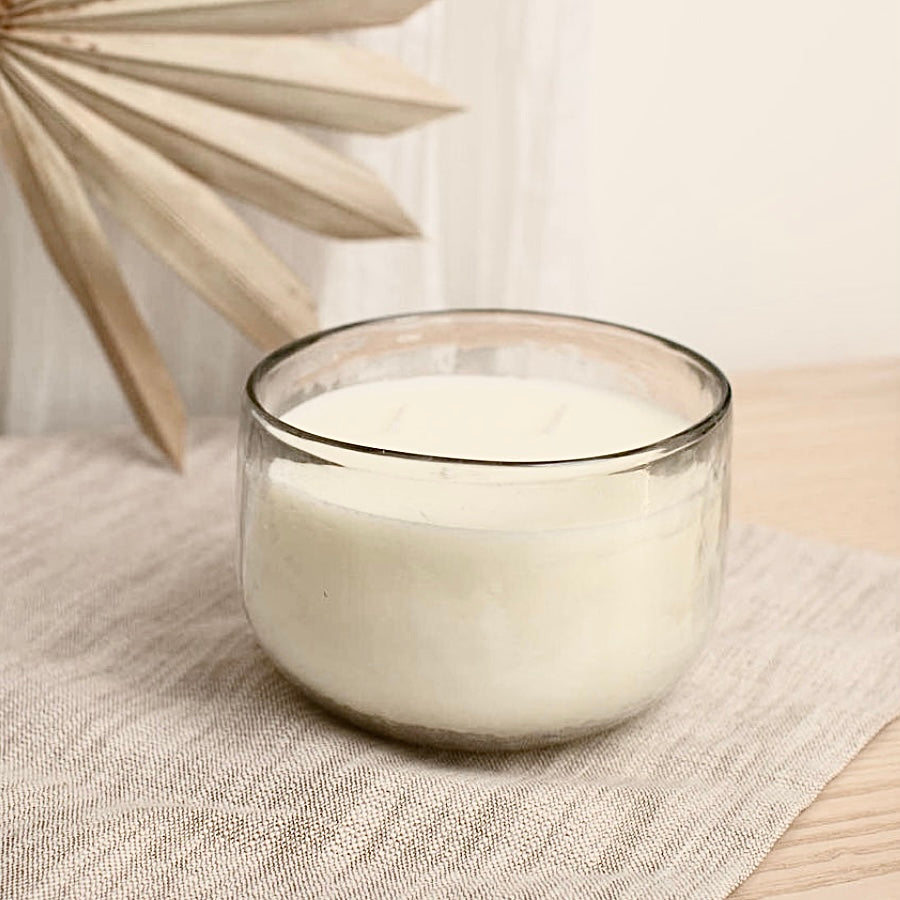 Glass candle on a textured surface with a blurred background