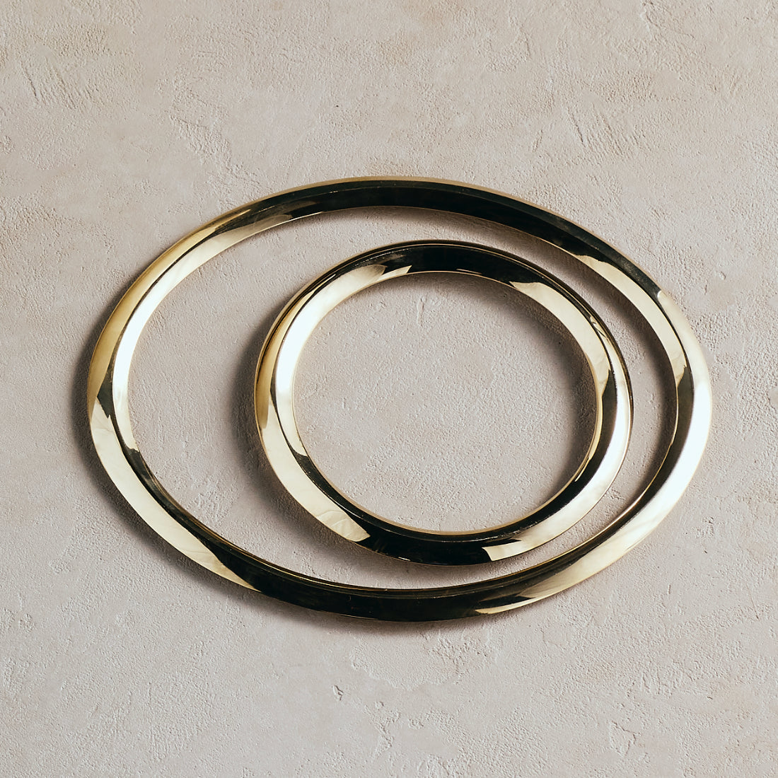 Set of three gold rings on a beige background