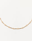 Gold chain necklace on a light gray background