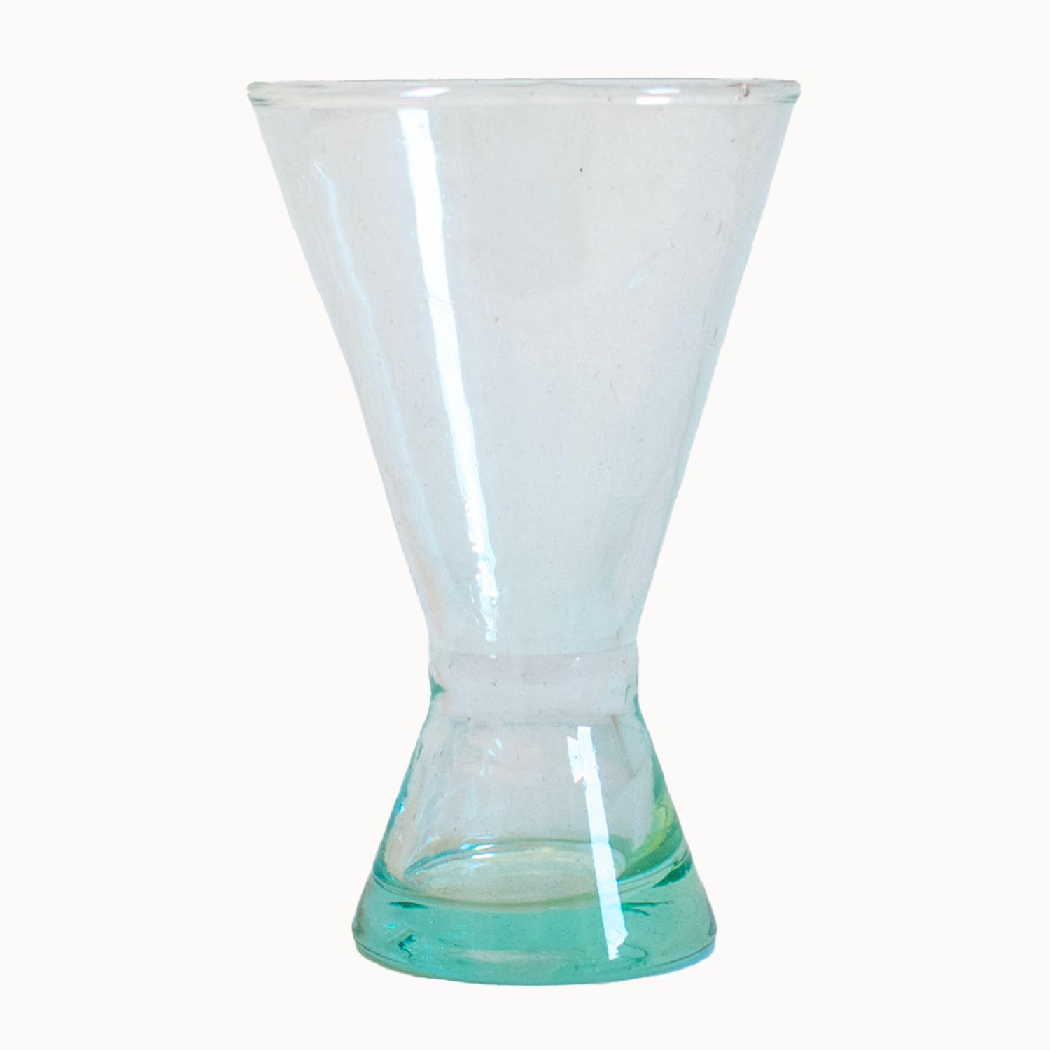 Clear cocktail glass with a cone shaped base on a white background