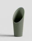 Green soil scoop on a light gray background