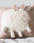 Cushion with a white bunny design on a pink background