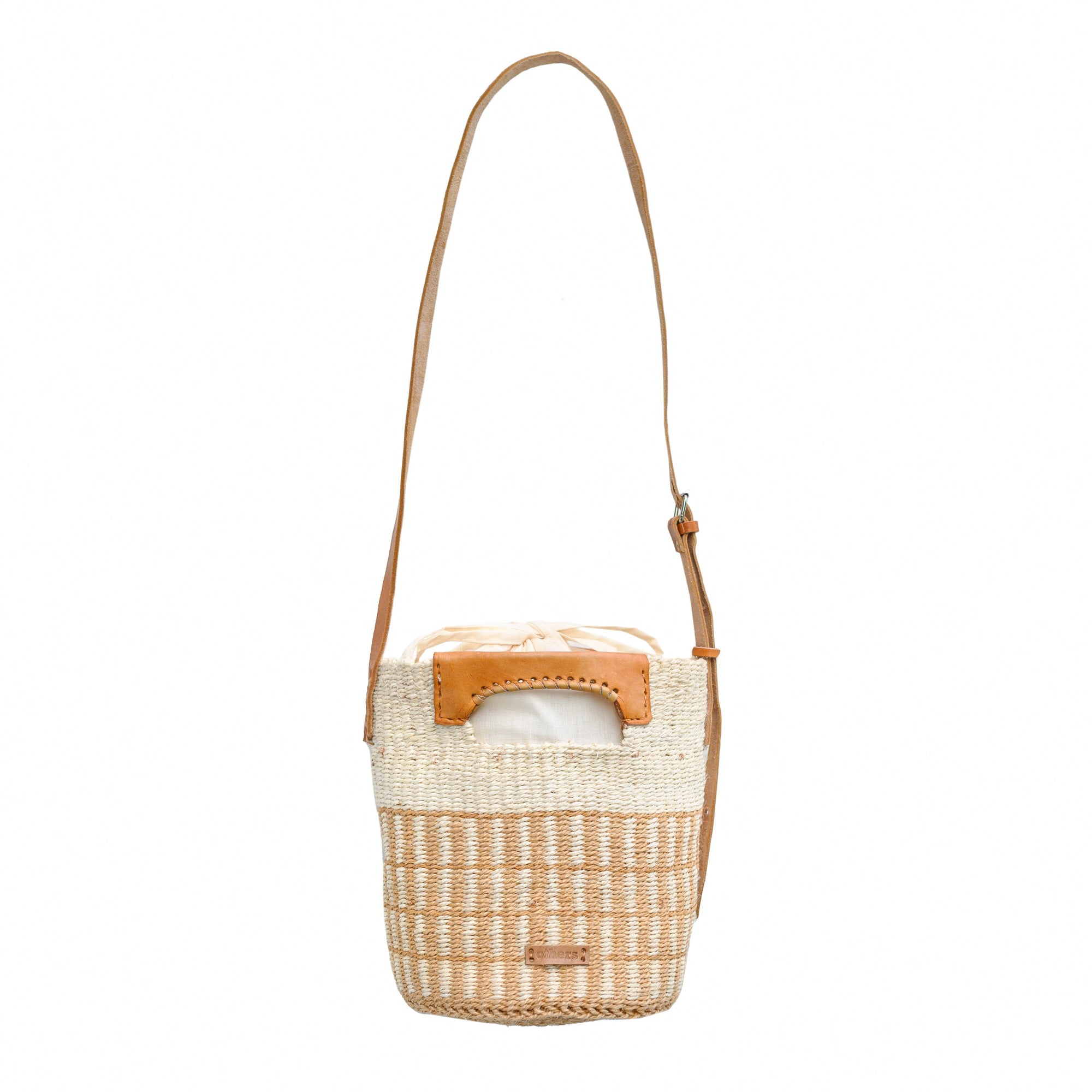 Woven handbag with leather handle and trim on a white background