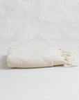 Folded beige towel on a light gray background