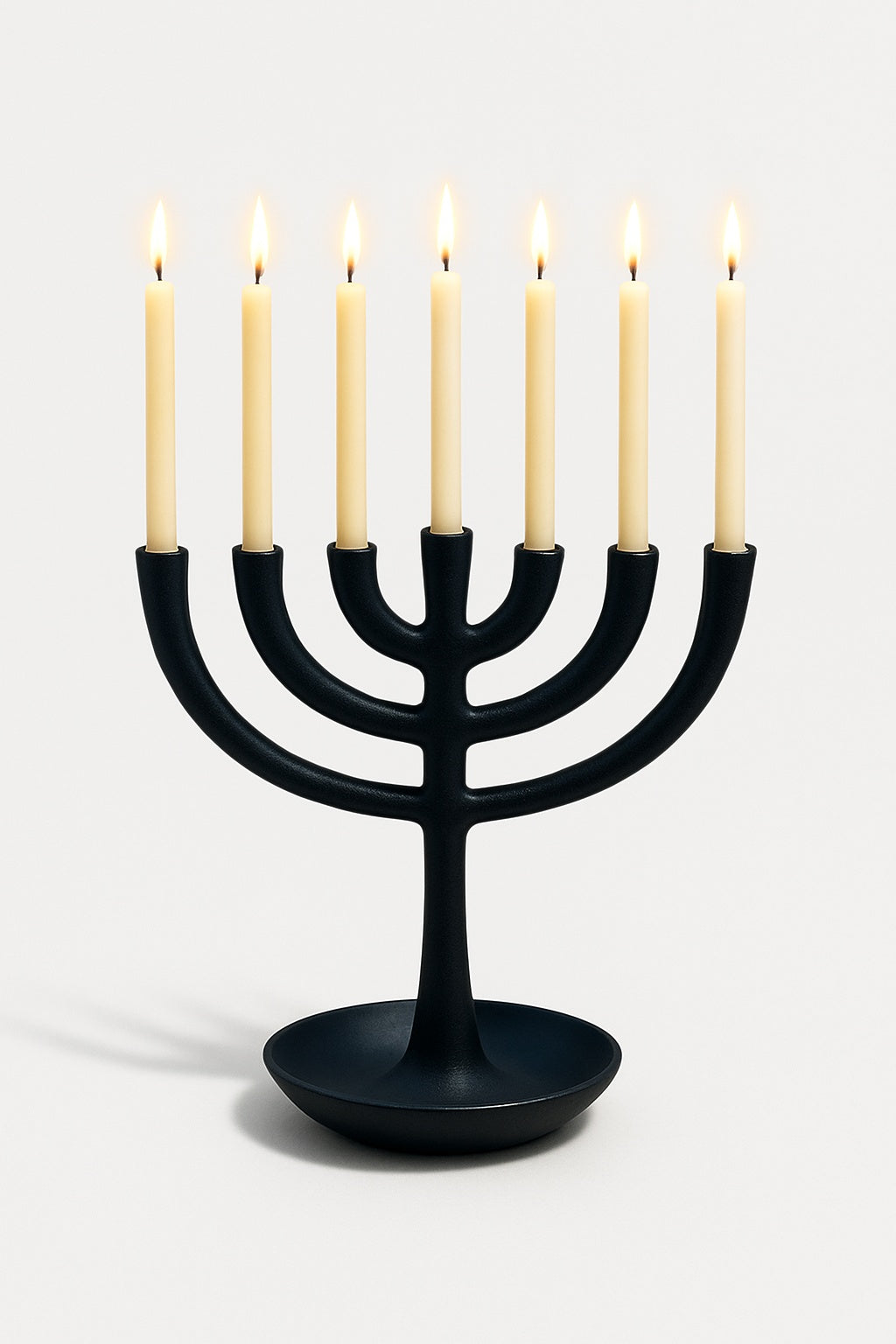 Black menorah with six lit candles on a white background
