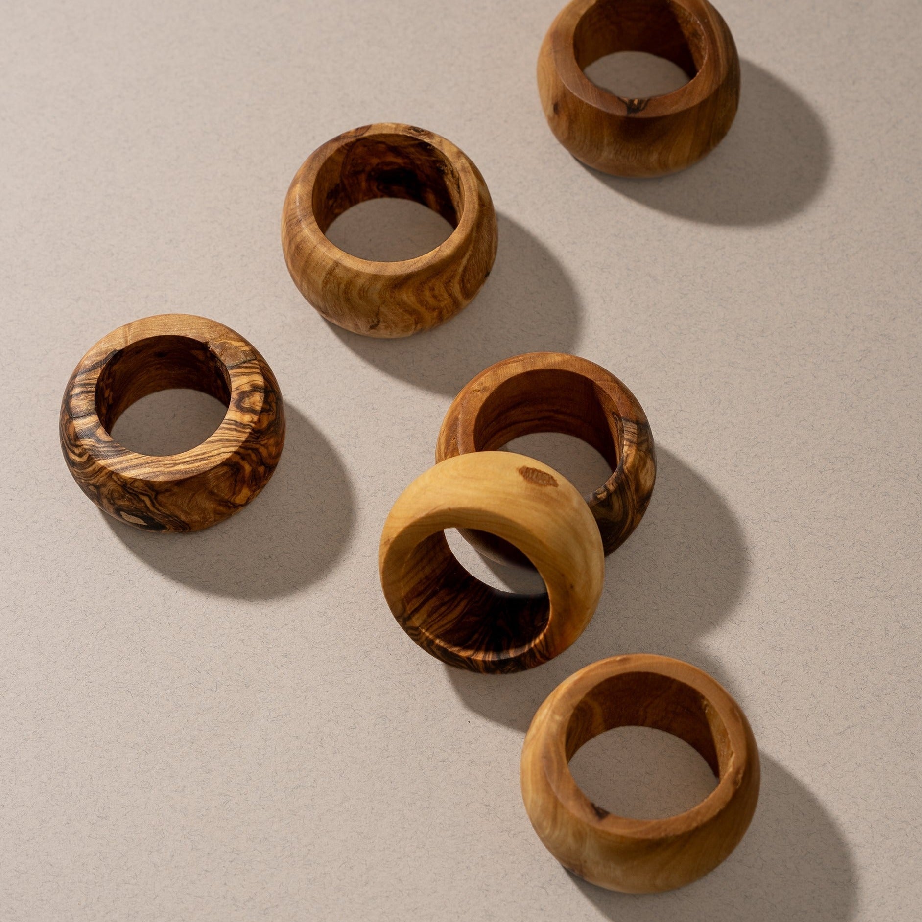 Set of six wooden napkin rings on a beige background