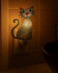 Cat-shaped night light on a wall switch in a bathroom
